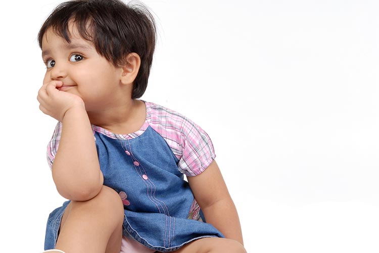 Adorable toddler sitting with her hand resting on her knee!