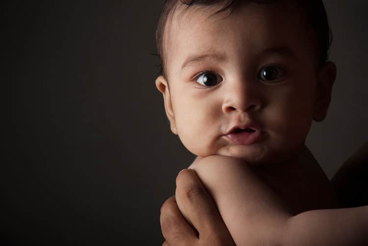 Newborn being held by his father/mother.