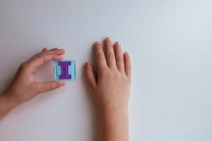 Child's hands holding the letter 'I' made out of felt material