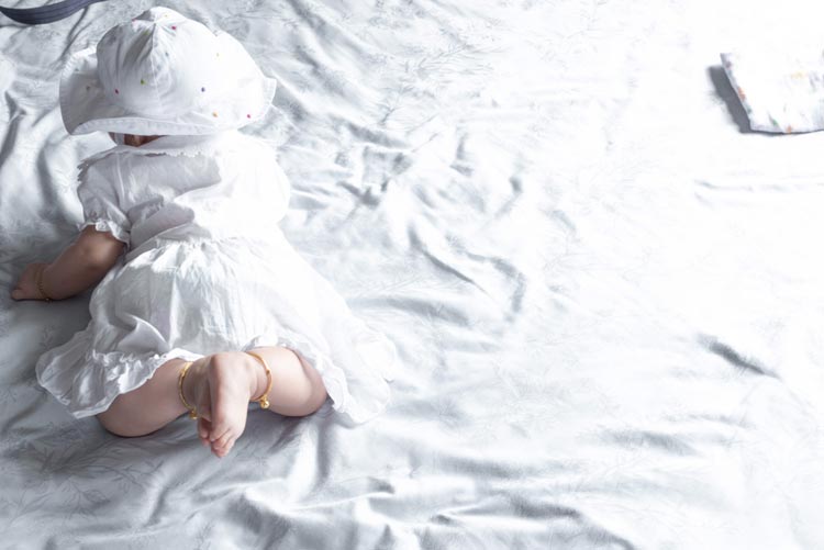 Baby in anklets and white dress