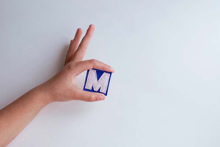 Child holding the letter M