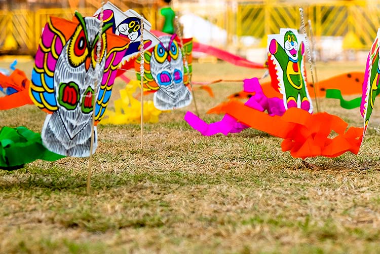 Colourful kites hung on a string.