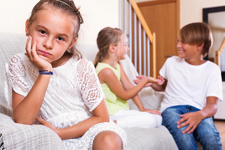 A middle child feeling left out while her sister and brother have fun.