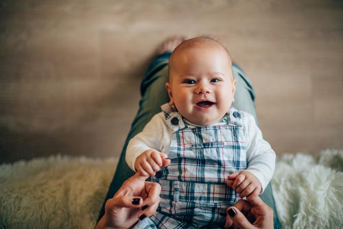 A mother holding a smiling baby.