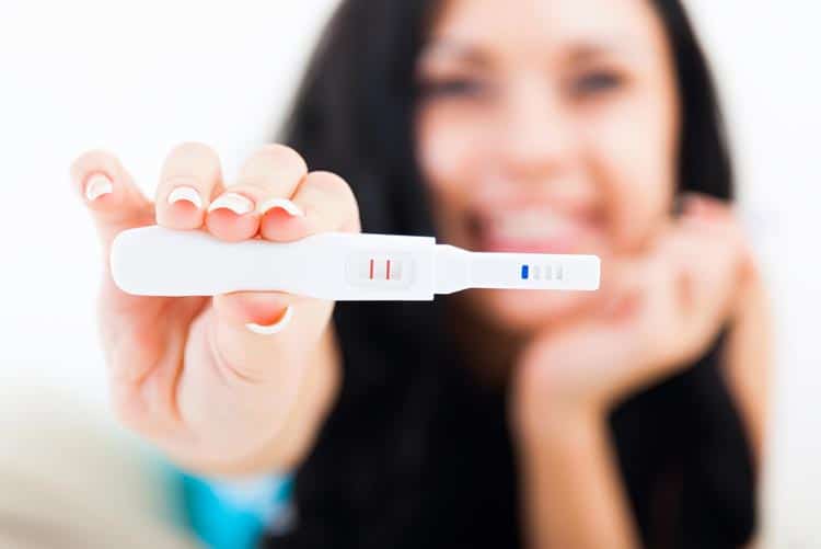 Woman holding a positive pregnancy test