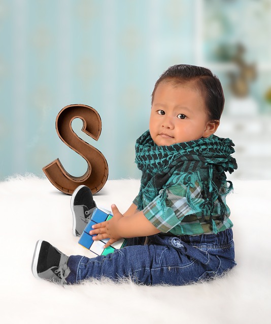 Boy sitting next to the standee of letter S