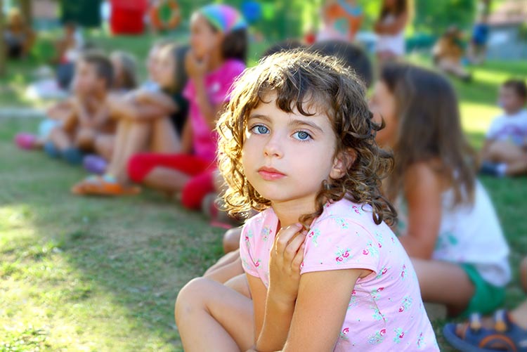 A child looking disinterested in a group.