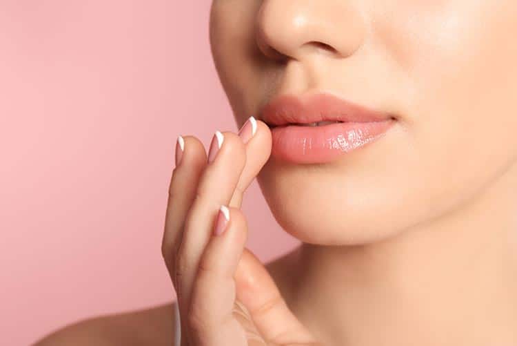 Woman applying lip balm to her lips