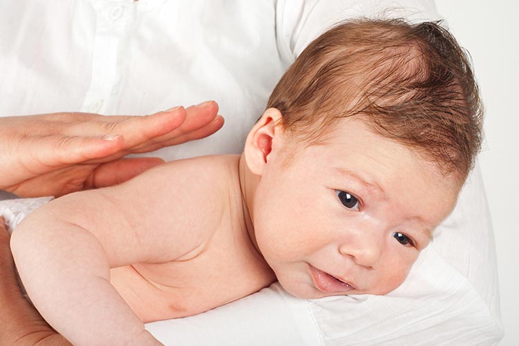 A parent patting the little one's back so that he could burp.