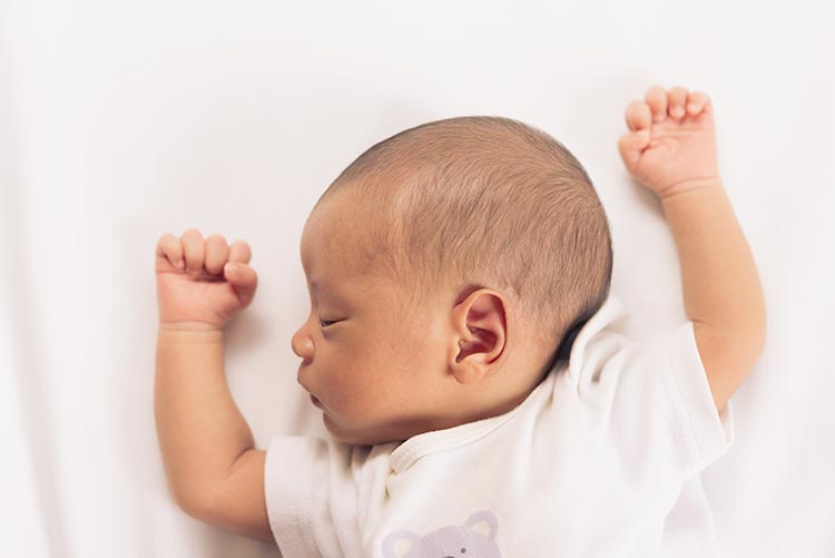 A newborn baby fast asleep.