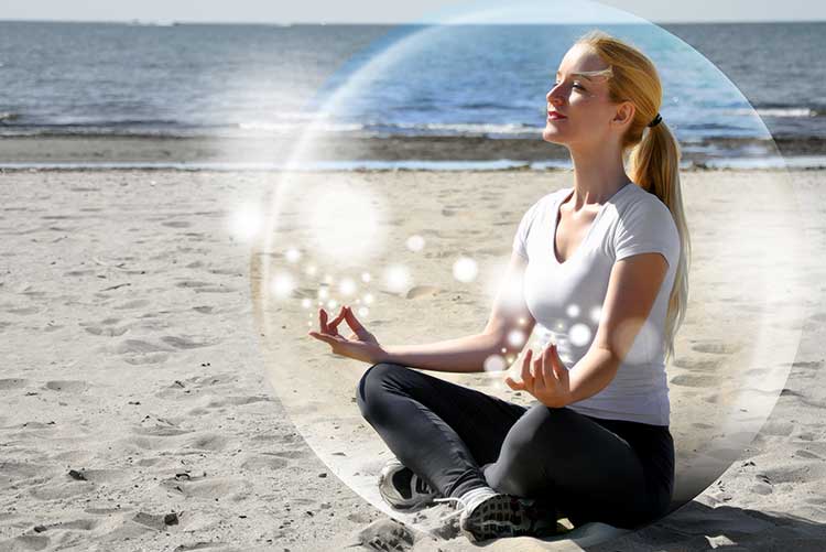 A girl meditating on the beach.