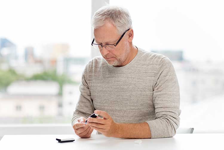 An old man checking his diabetes level.