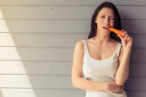 Woman eating carrot