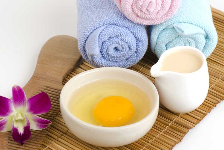 Curd and eggs in glass bowls along with towels and comb.