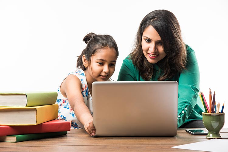 A mother teaching her daughter at home using innovative material.