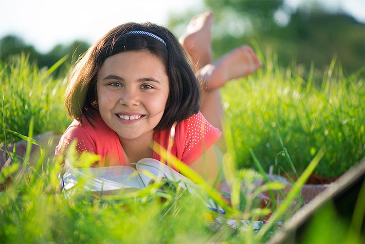 A young girl studying outdoors.