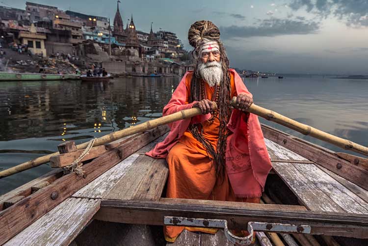 A Sadhu Baba rowing a boat in Varanasi.