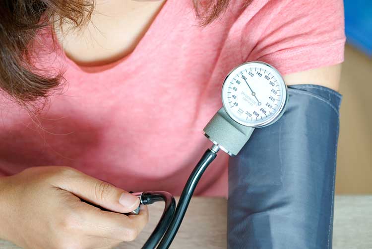 Woman checking her blood pressure using a machine.