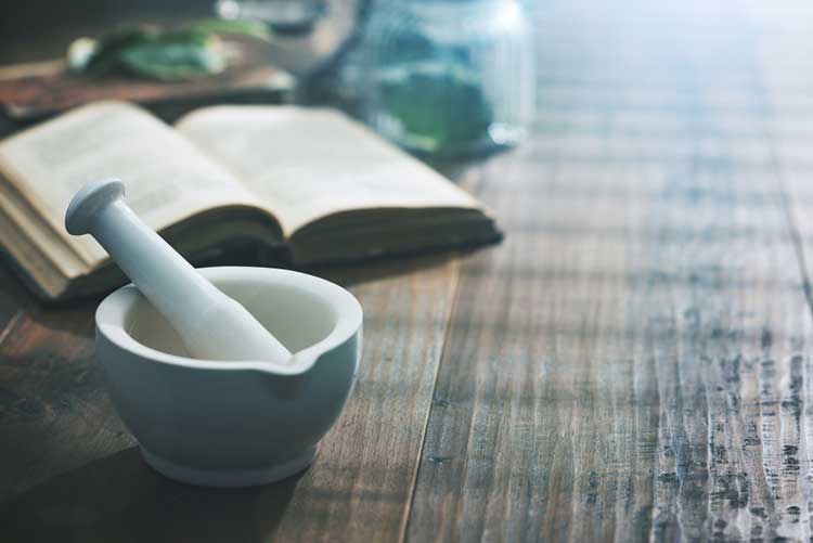 Mortar and pestle next to an open book