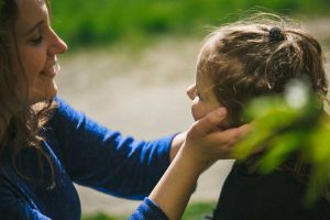 Mother holding her daughter by the cheeks!