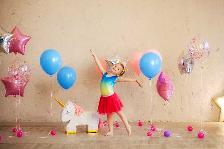 A girl dances around pretty balloons.