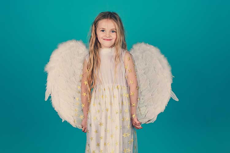 A young girl dressed in beautiful wings smiles at the camera.
