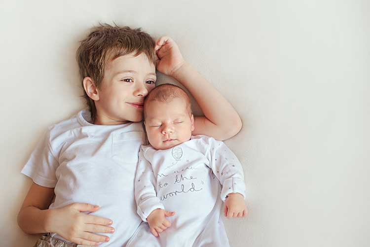 A big brother poses with his little brother at a studio photoshoot.