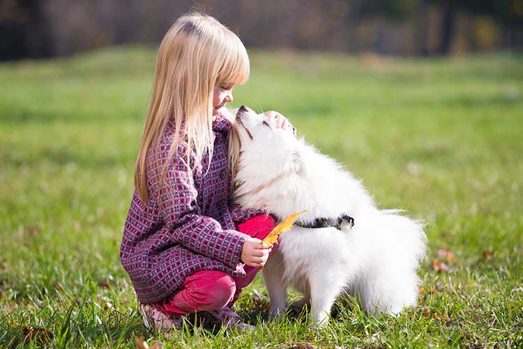 A young girl pets her pet.