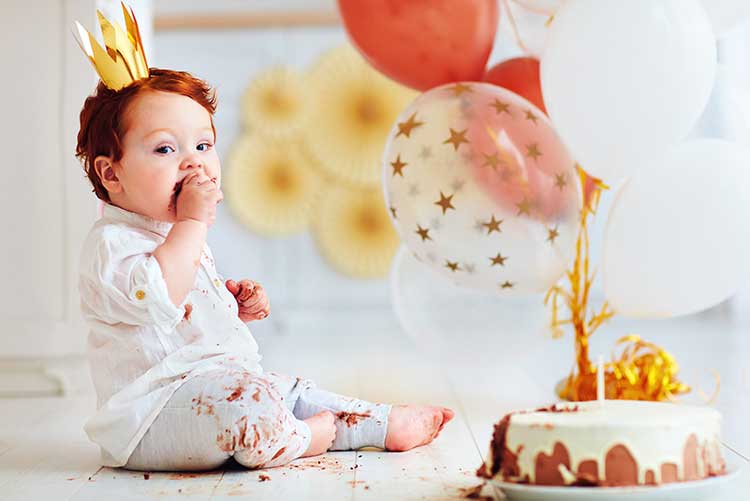 A baby boy munching on his birthday cake.